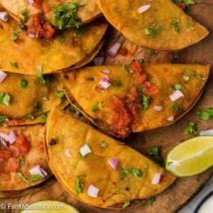 Fried tacos on wooden cutting board.