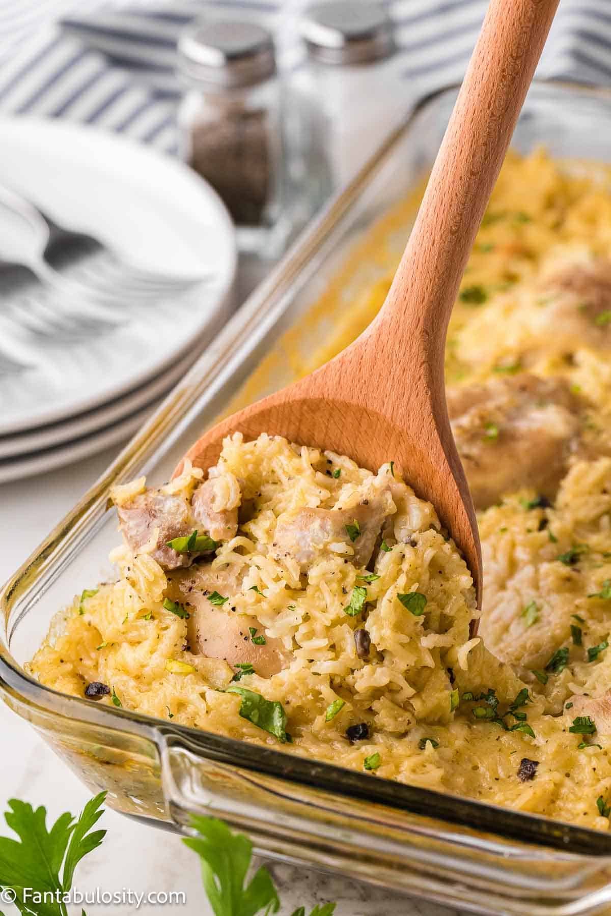 Old fashioned chicken and rice casserole being scooped out of baking dish.