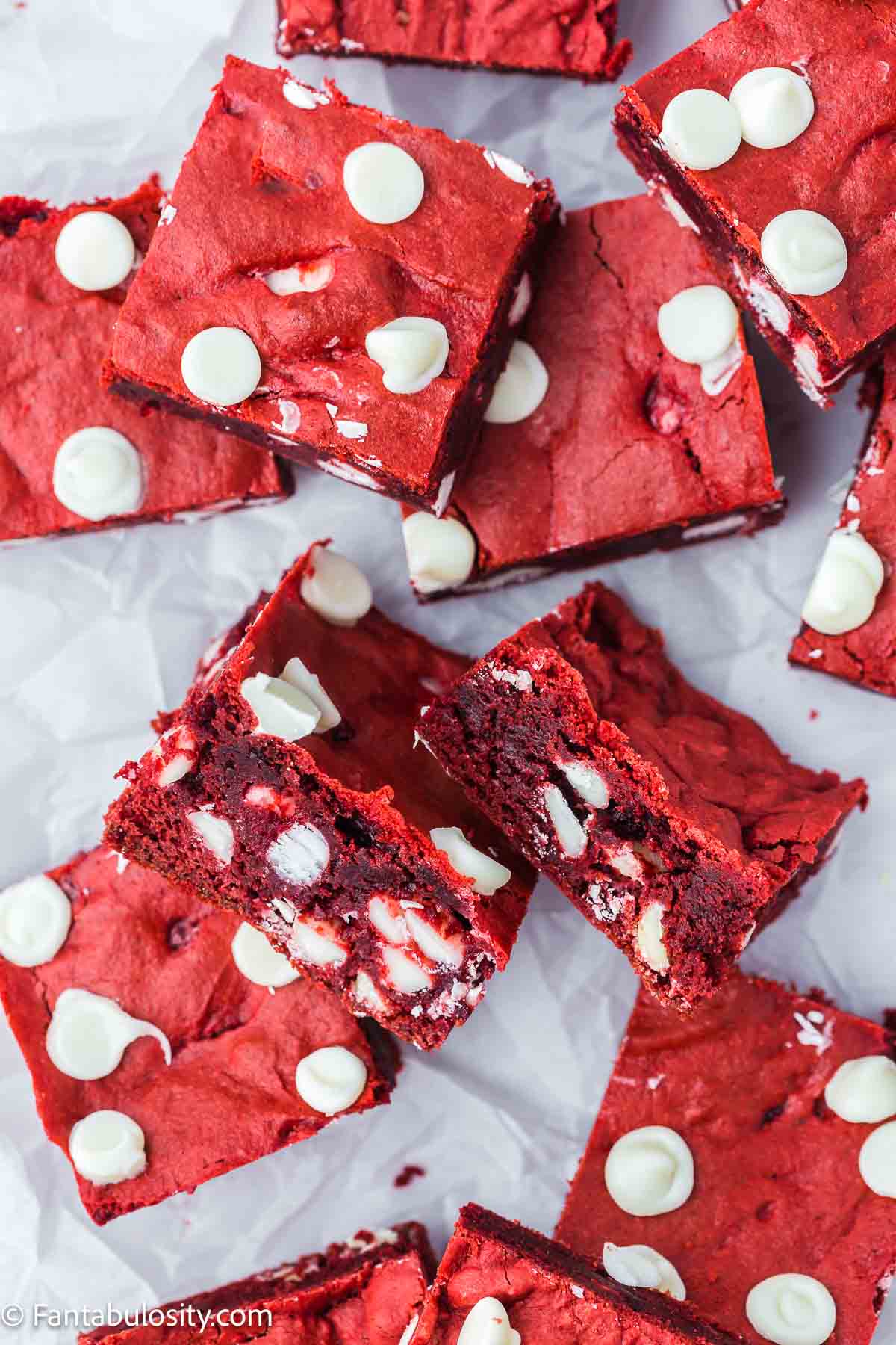 Red velvet brownies cut in to squares on white parchment paper.