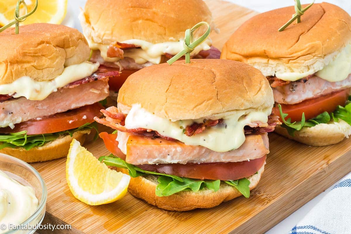 Salmon sliders on wooden cutting board.