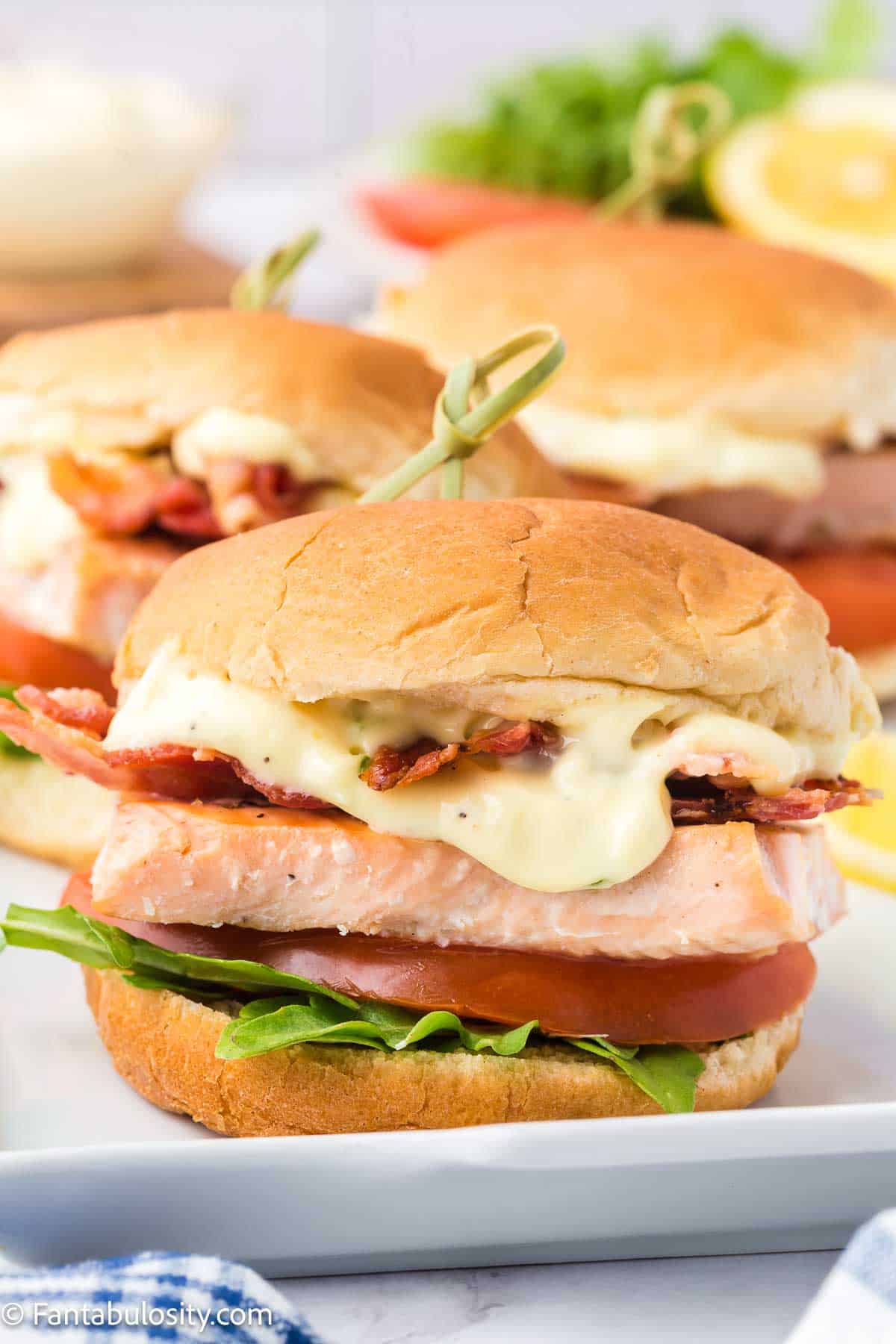 Salmon sliders on white platter.