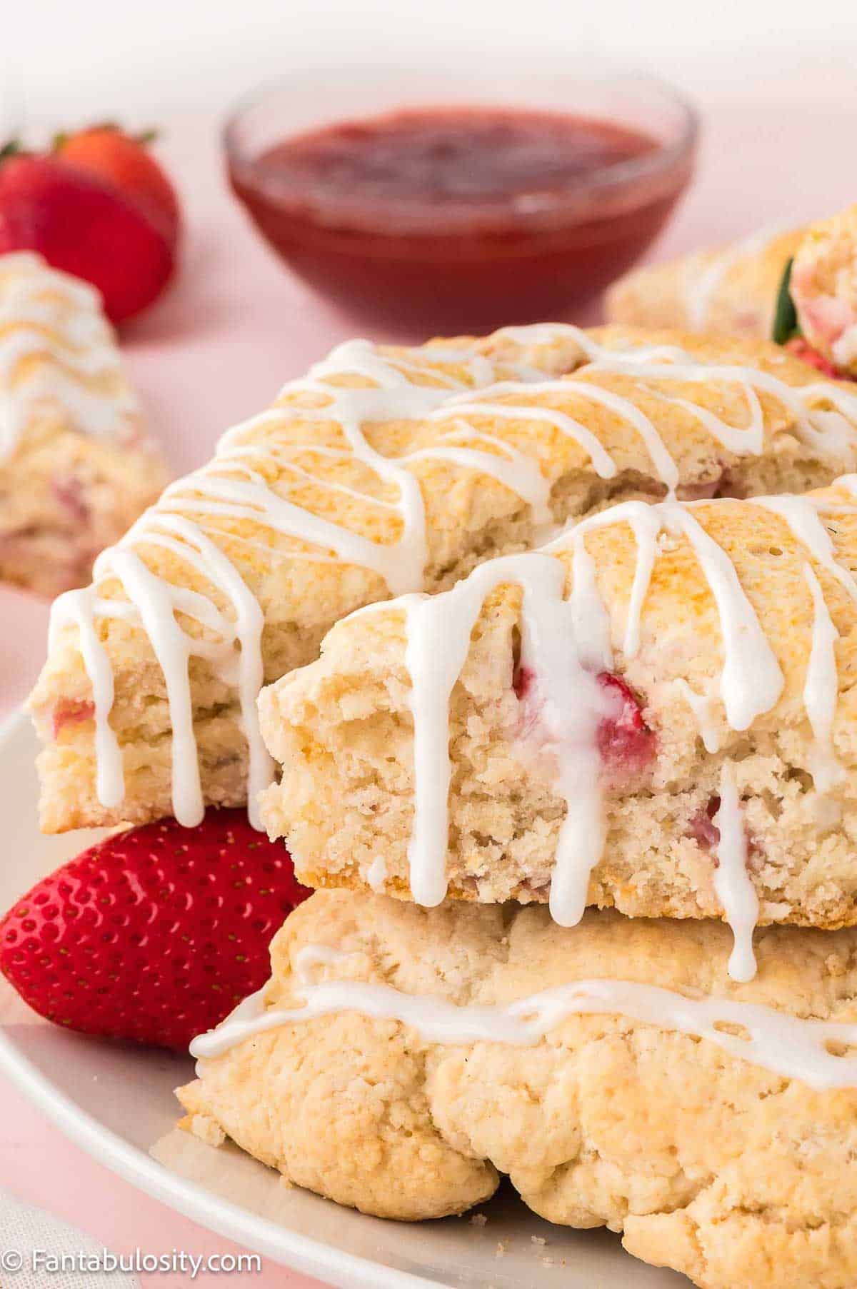 Close up of strawberry scones, sitting on white plate.