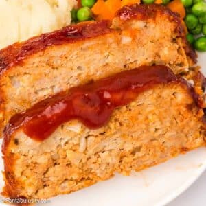 Slices of chicken meatloaf on a white plate.