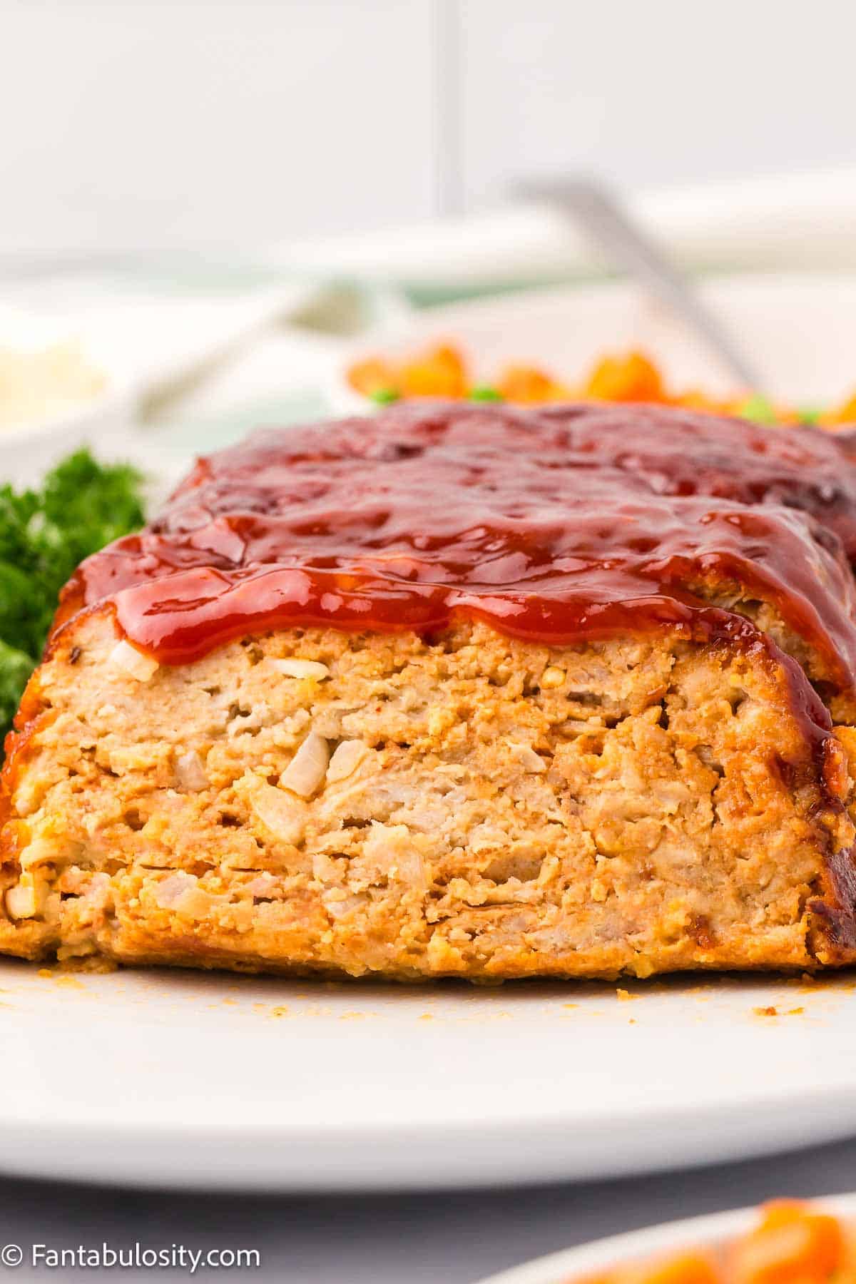 Cooked chicken meatloaf on white platter.