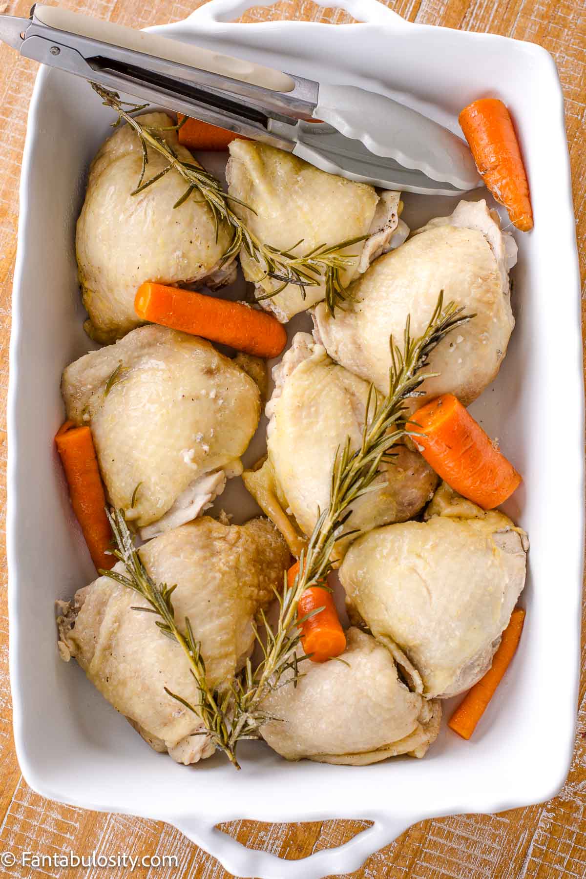 Boiled chicken thighs in baking dish.