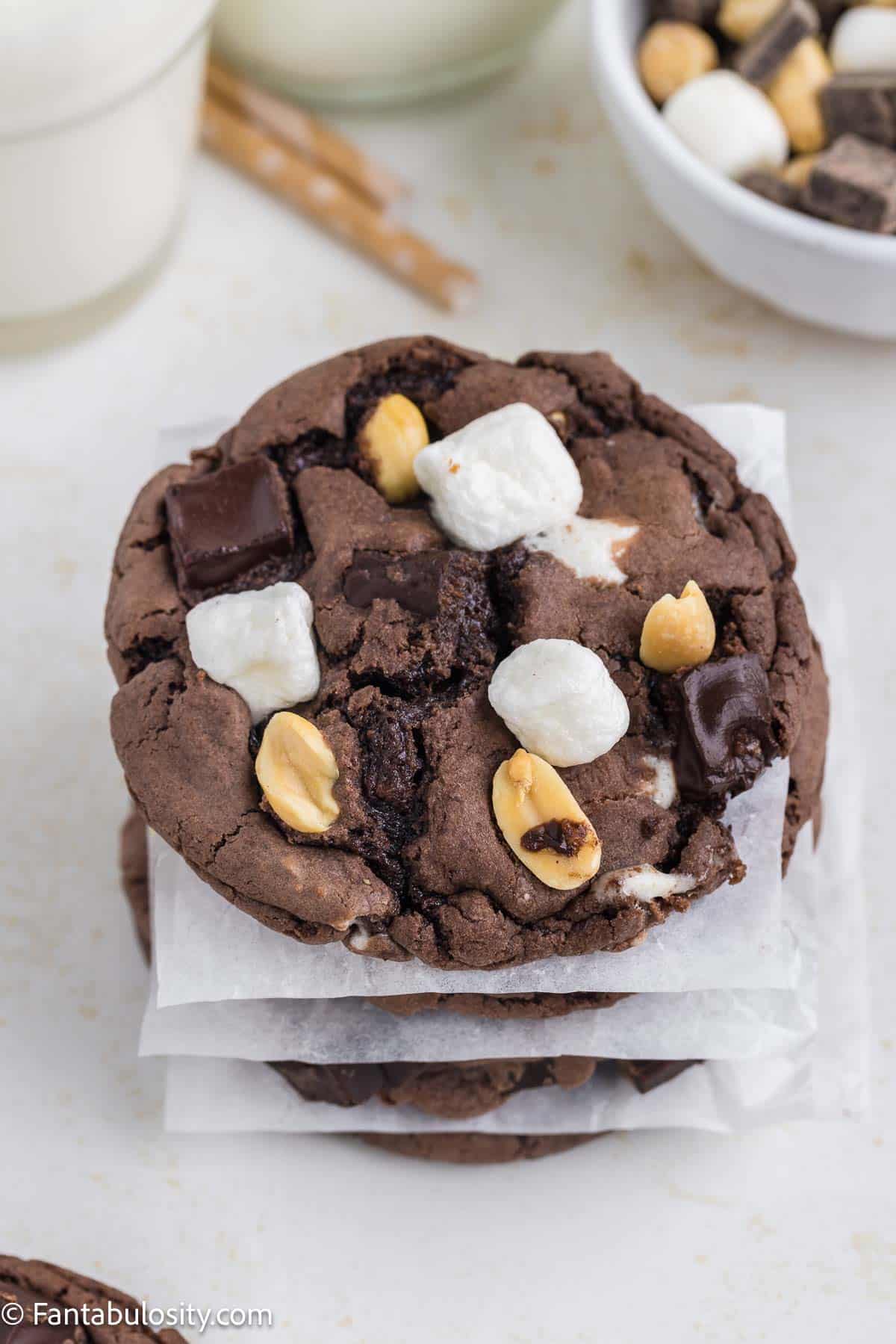Stacked rocky road cookies, separated by wax paper.