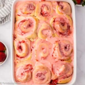 Baked strawberry cinnamon rolls in baking dish.