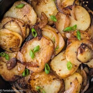 Fried potatoes and onions in cast iron skillet.