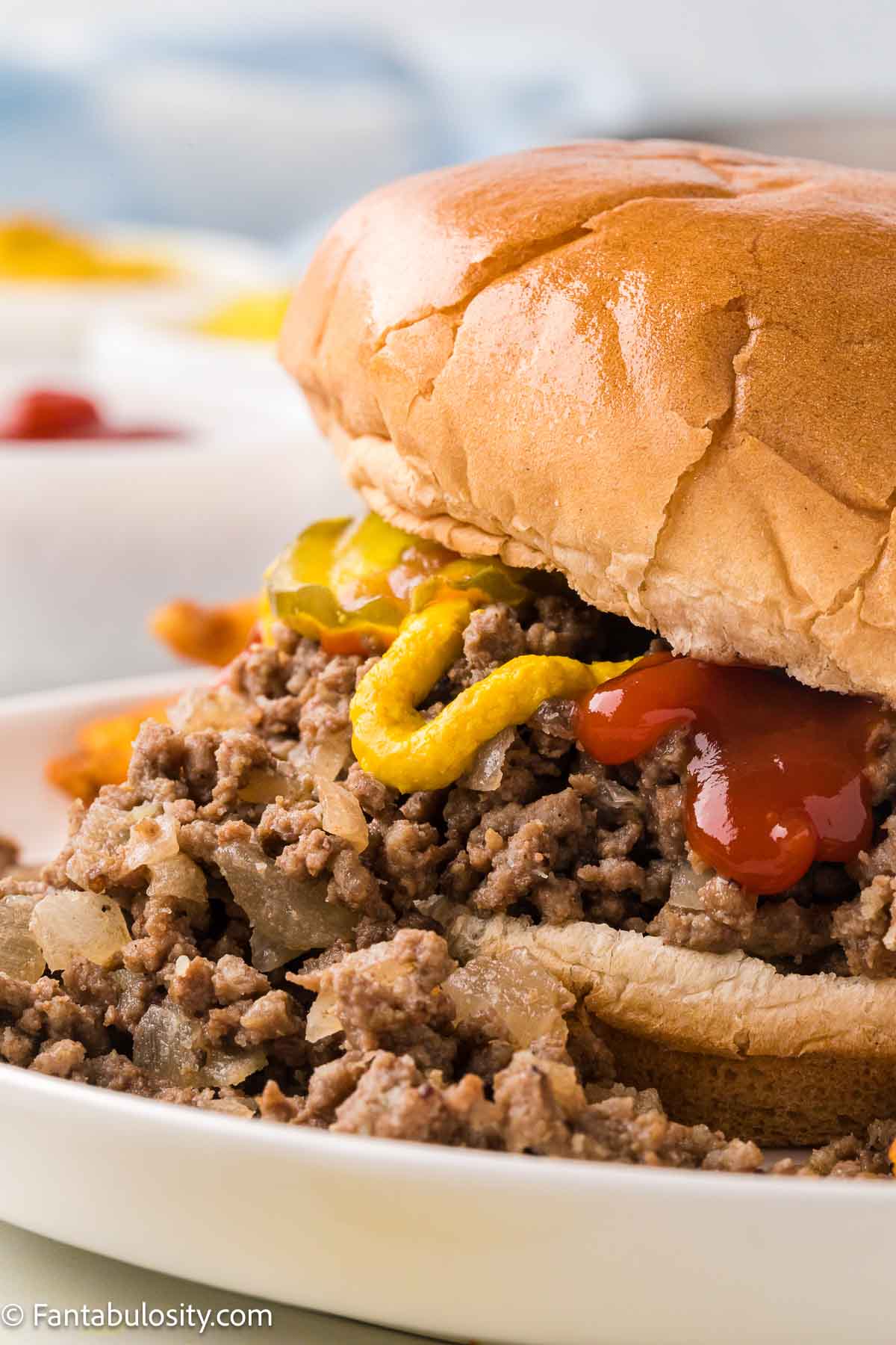 Close up of maid rite sandwich sitting on white plate.