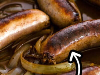 Close up of cooked bratwursts in cast iron skillet.