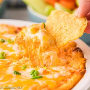 Close up of chip dipping in to buffalo chicken dip.