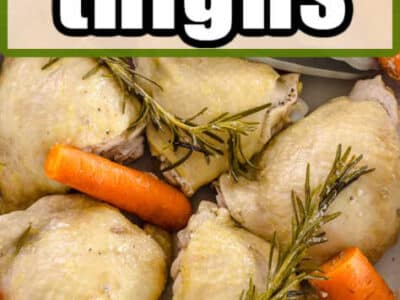 Close up of boiled chicken thighs with carrots and herbs.