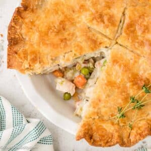 Homemade Chicken Pot Pie in white pie dish, with a peek at the veggies and chicken.