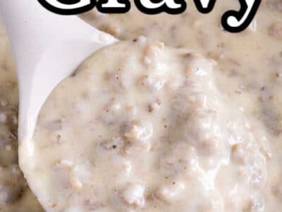 Sausage gravy being scooped up with a spoon, out of a pan.