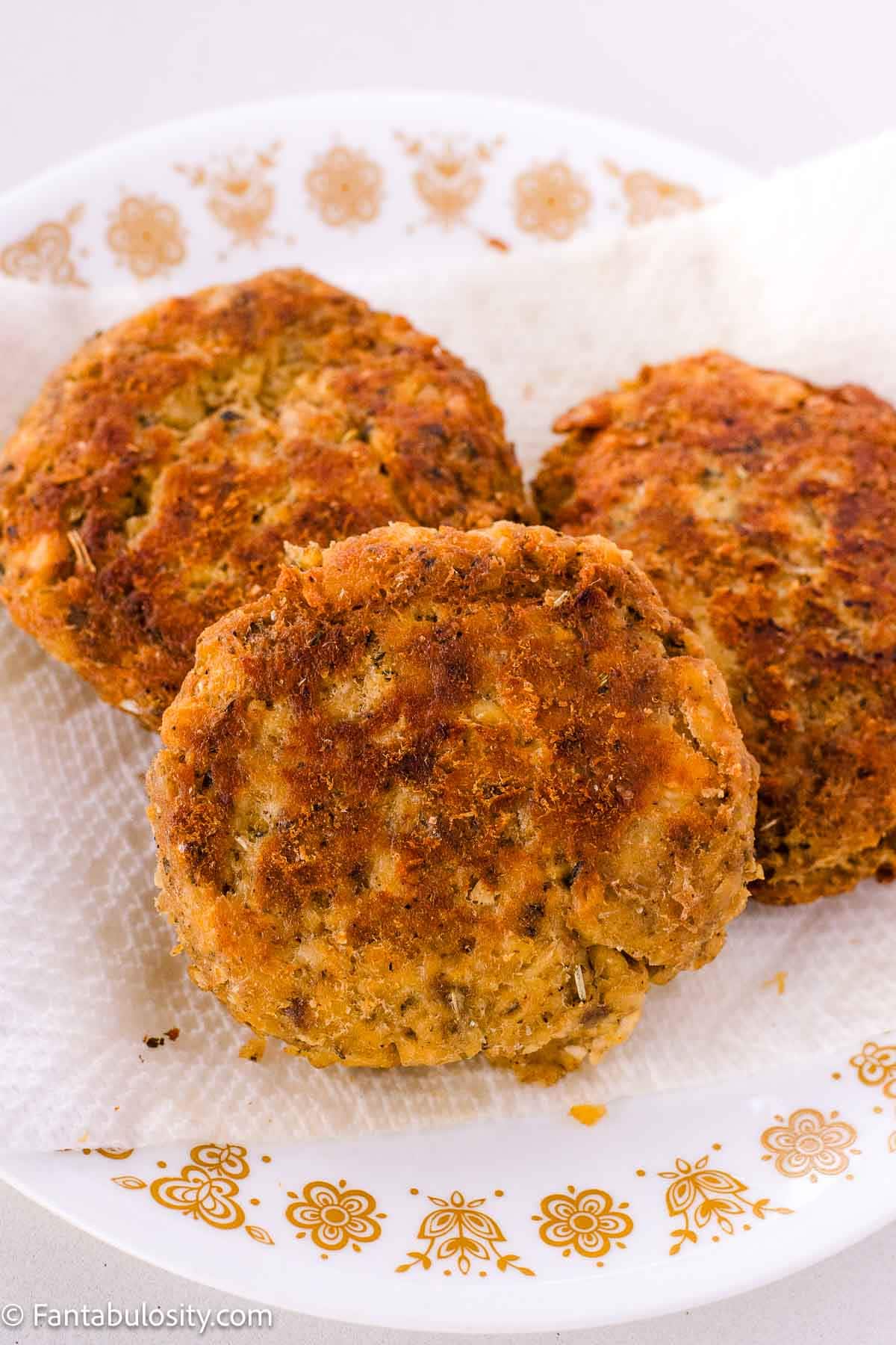 Old-Fashioned salmon patties sitting on Corelle plate. 