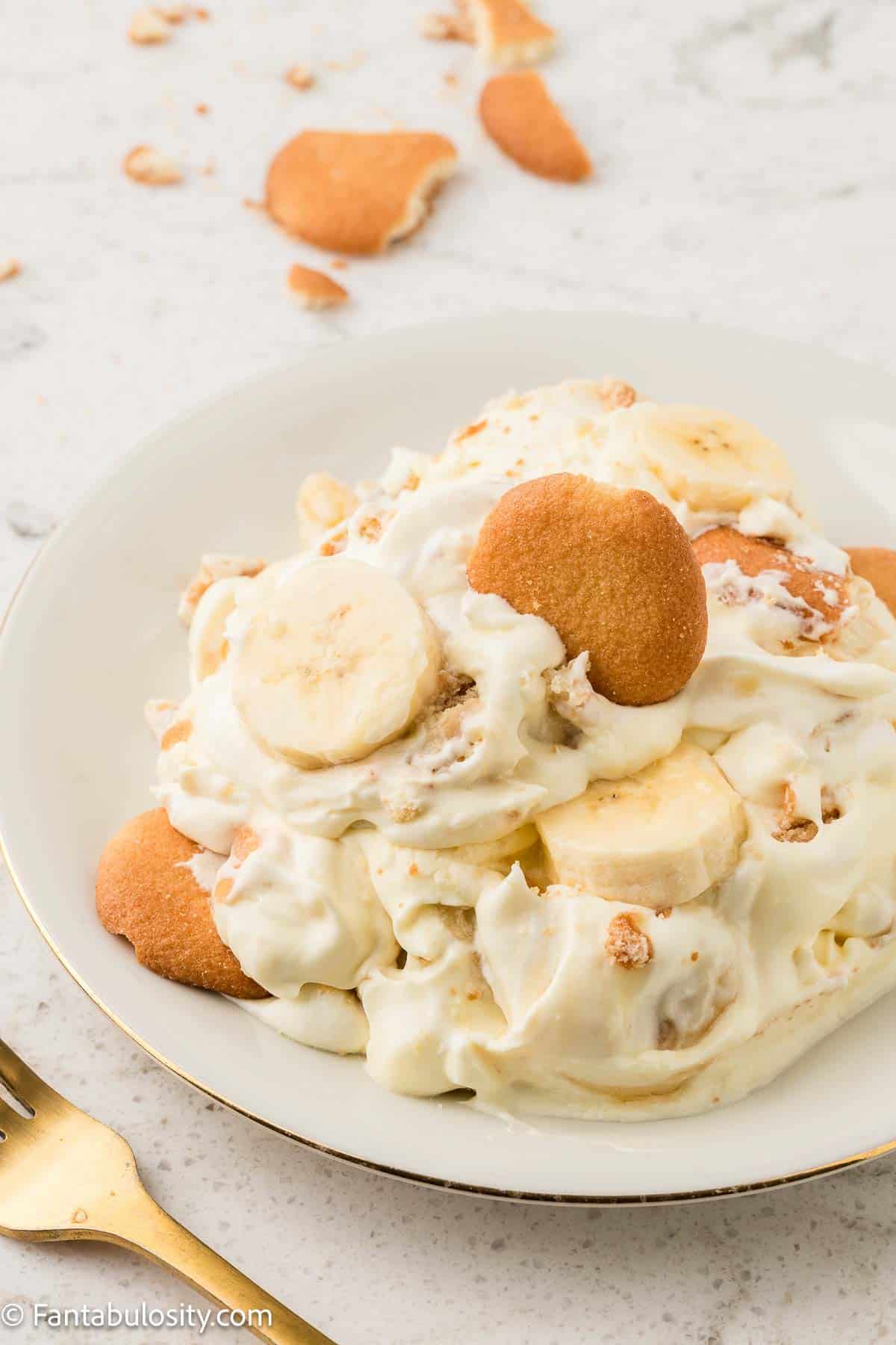 Serving of banana pudding on white plate.