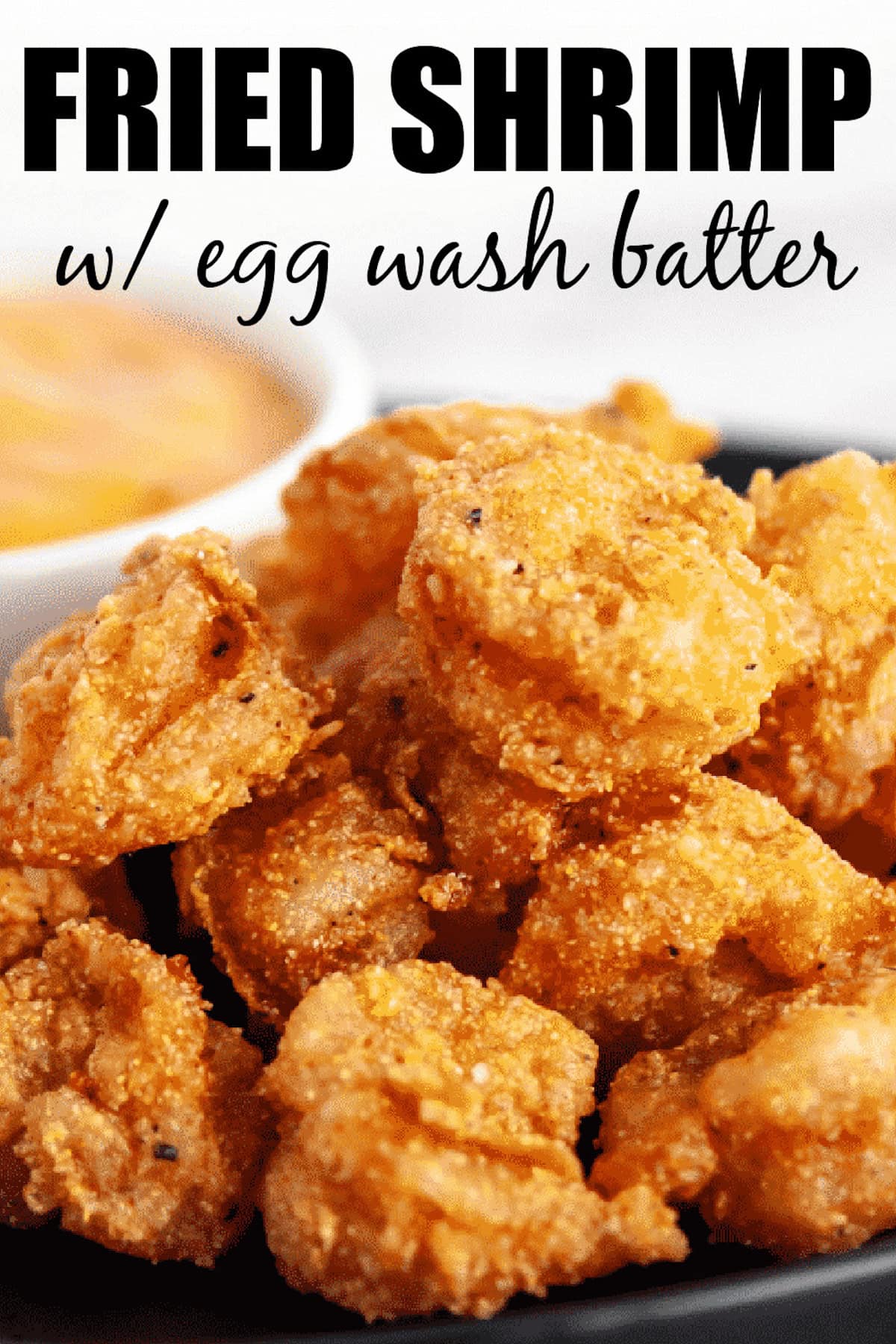 Fried shrimp on plate next to dipping sauce.