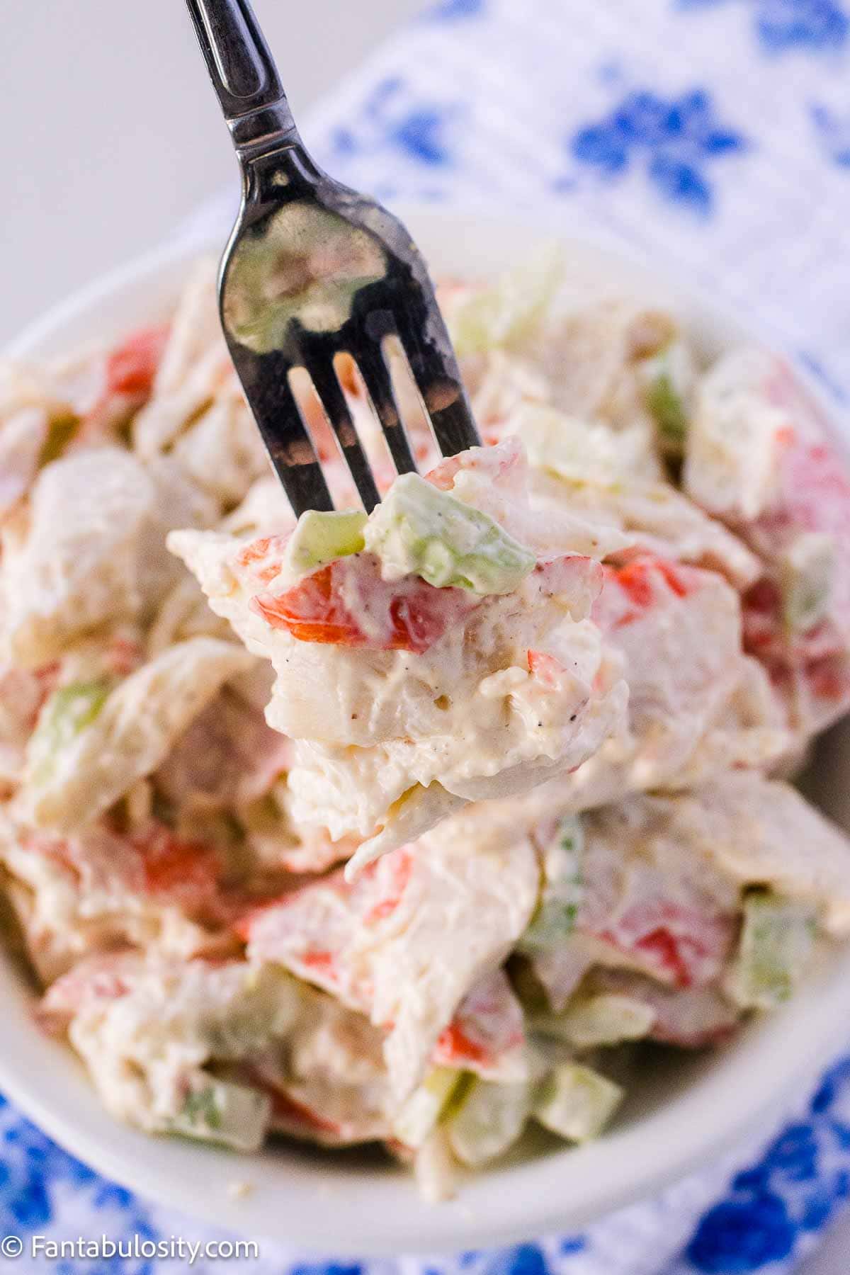 A fork holding a bite of crab salad.