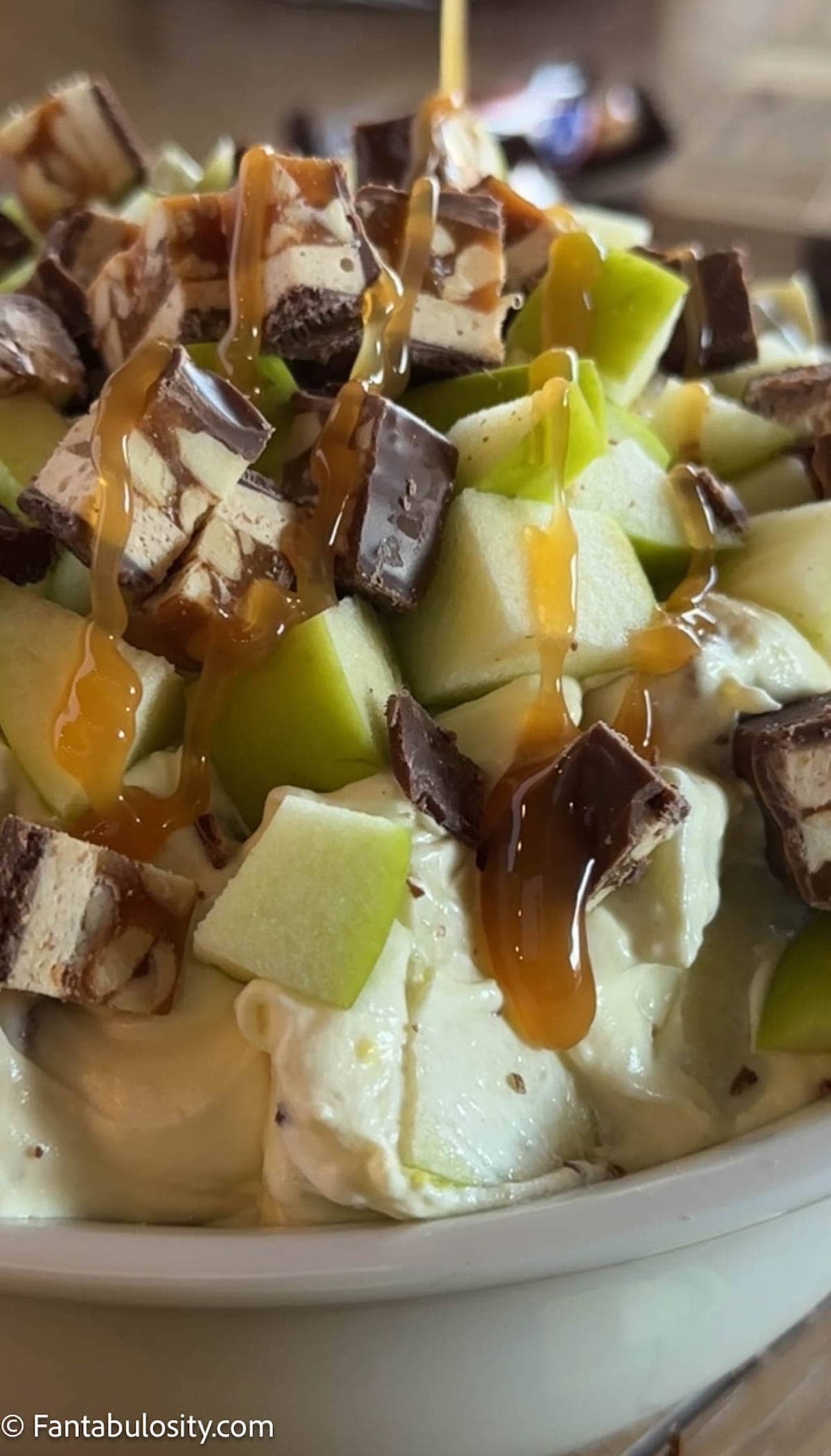 Snicker Apple Salad in bowl, with caramel drizzle on top.