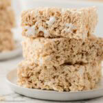 Three rice krispie treats made with marshmallow fluff, stacked on top of one another.