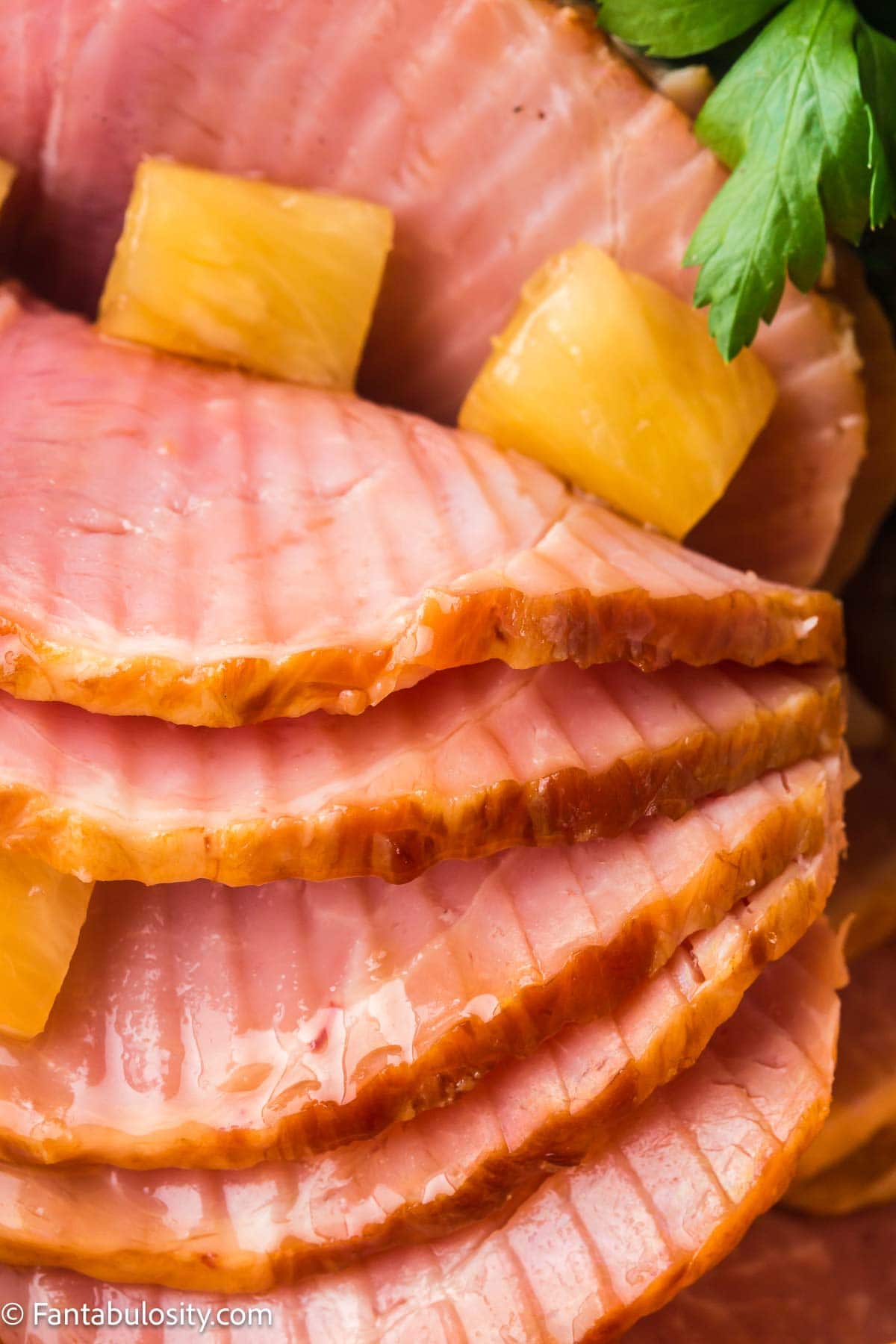 Ham cooked in the slow cooker, topped with pineapple.