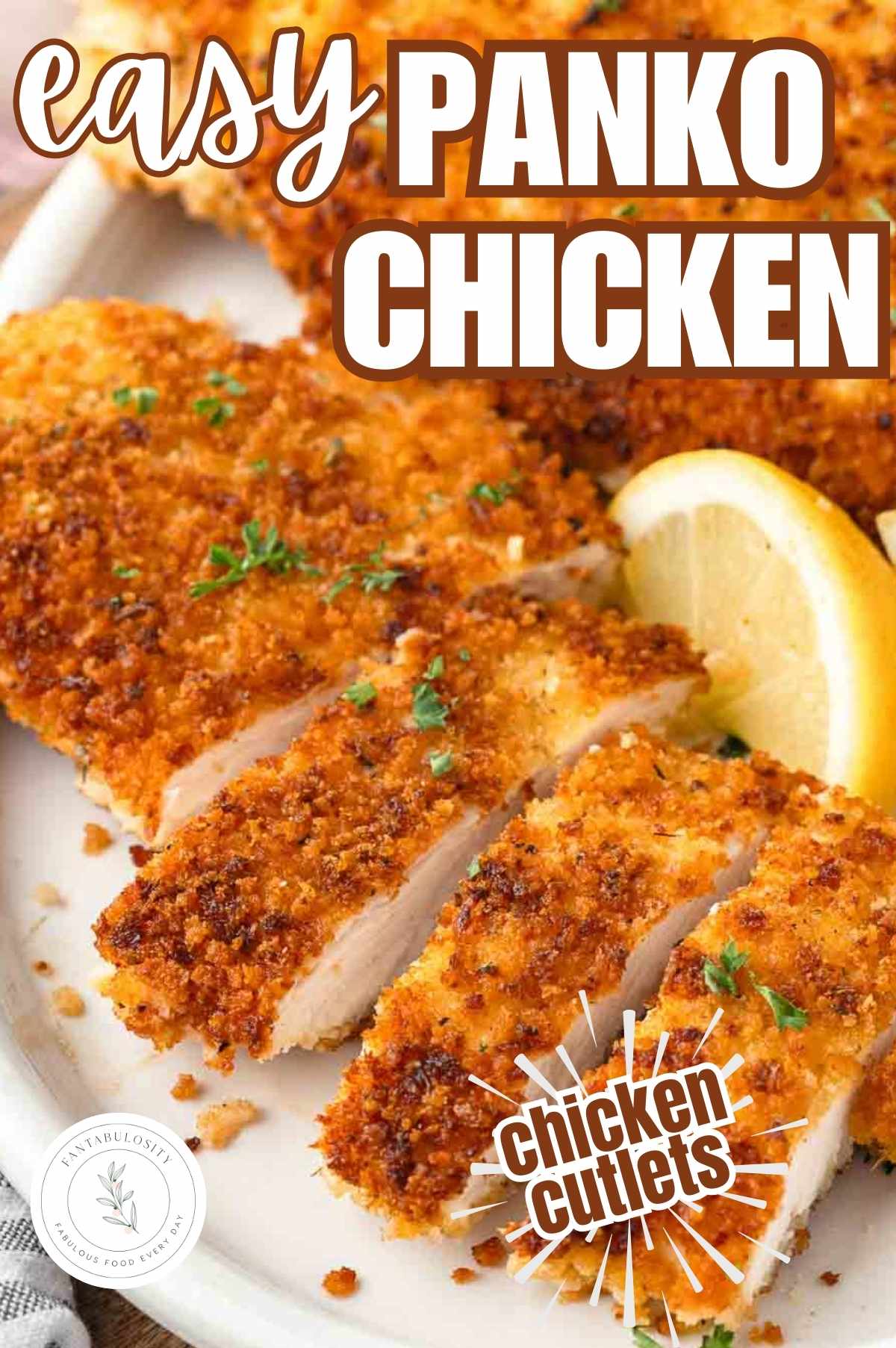 Panko Chicken cutlets on plate, next to lemon wedges.