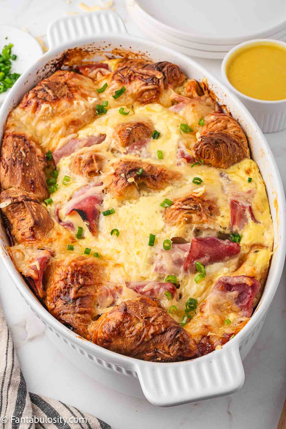 Baked ham and cheese croissant bake in baking dish.