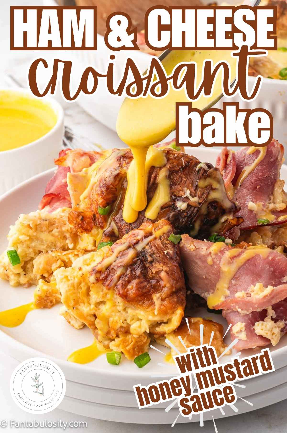 Ham and cheese croissant bake serving on plate with honey mustard spooning on top.
