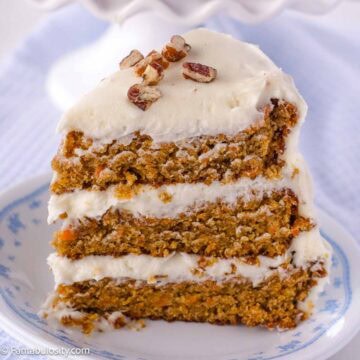 A slice of old-fashioned carrot cake with cream cheese icing on a vintage plate.