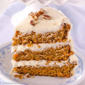 A slice of old-fashioned carrot cake on round, vintage plate.
