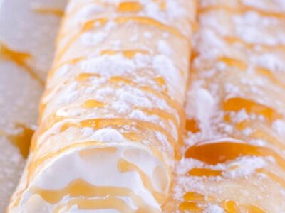 Three crepes stacked on top of one another, filled with a cream cheese, and whipped cream filling.