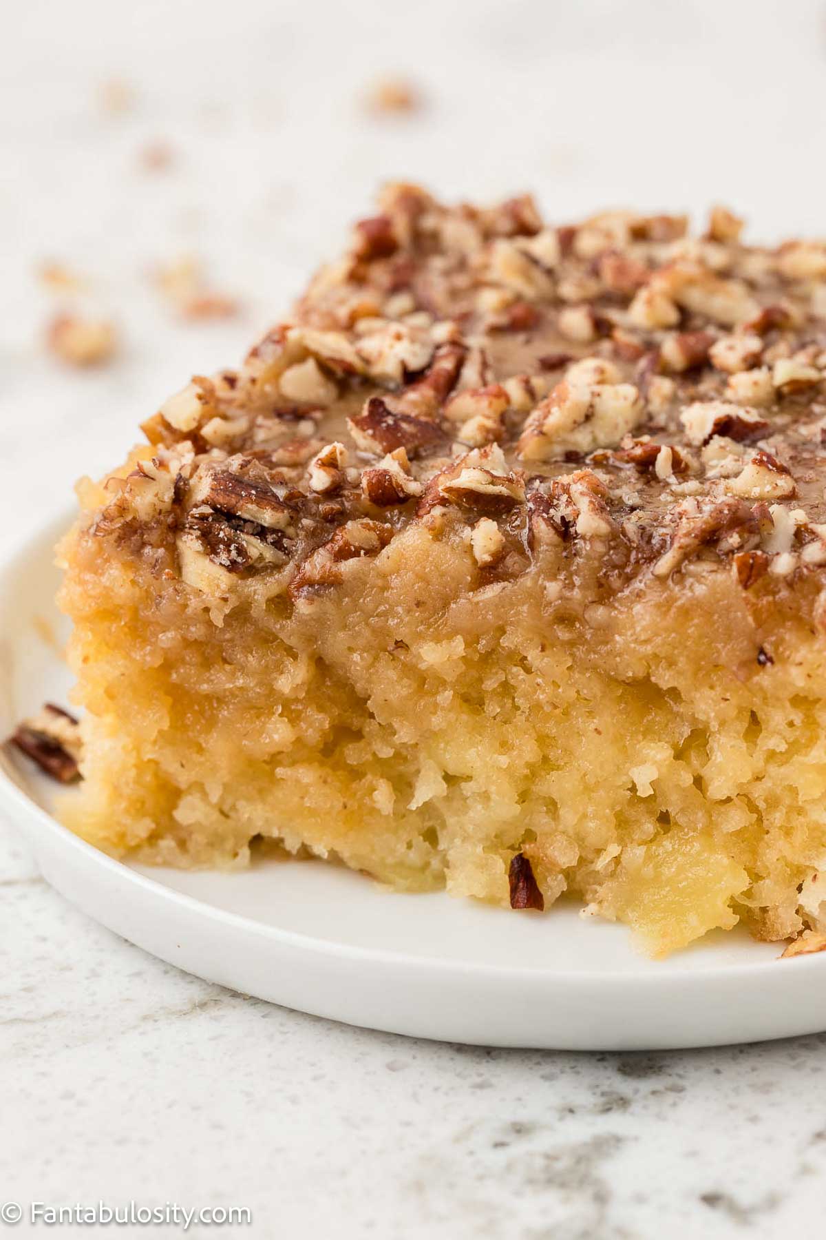 One slice of granny cake sitting on plate, showing topping and moist cake.