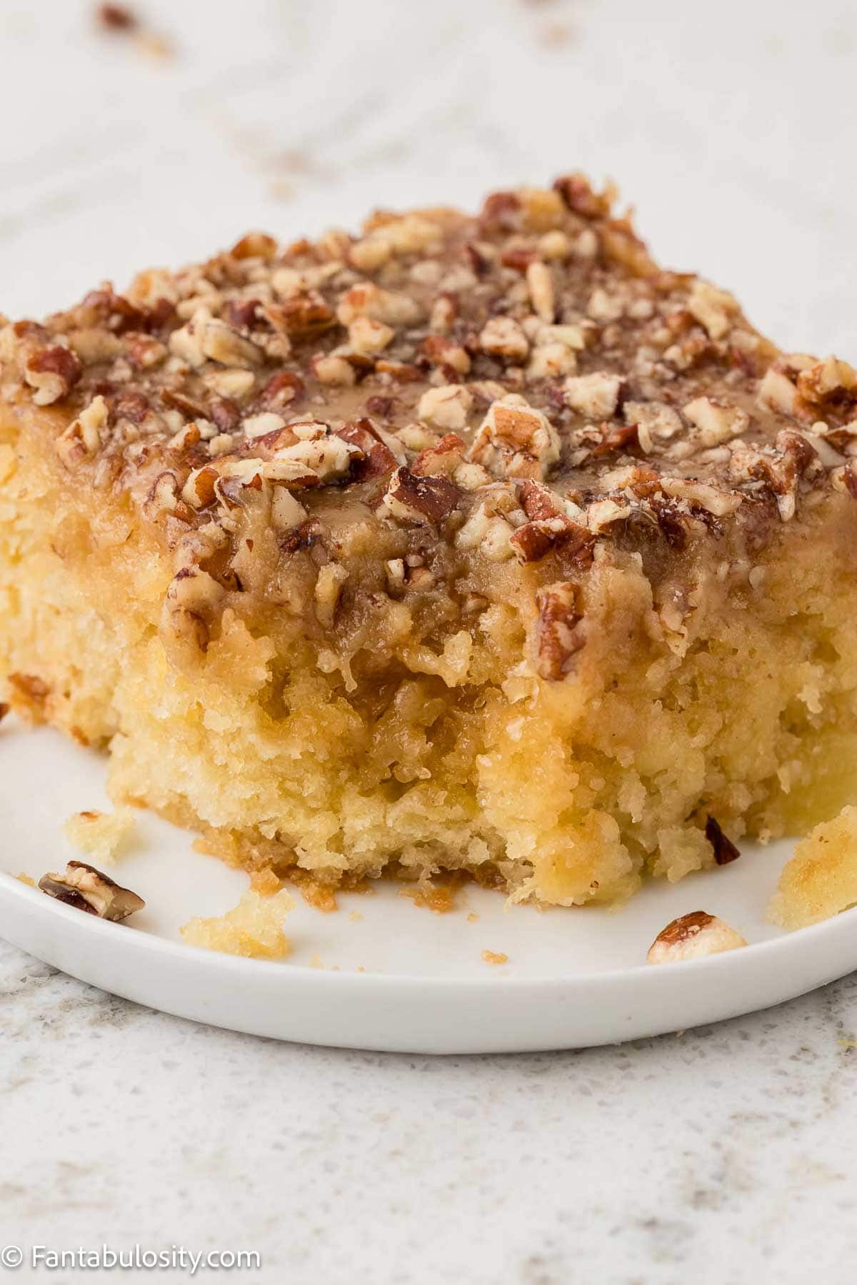 Slice of granny cake on small plate, with bite taken out of it.