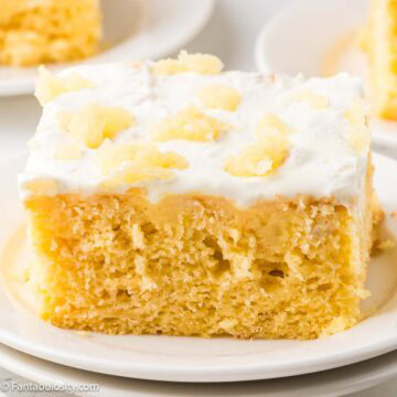 A slice of pineapple sunshine cake on a round plate.