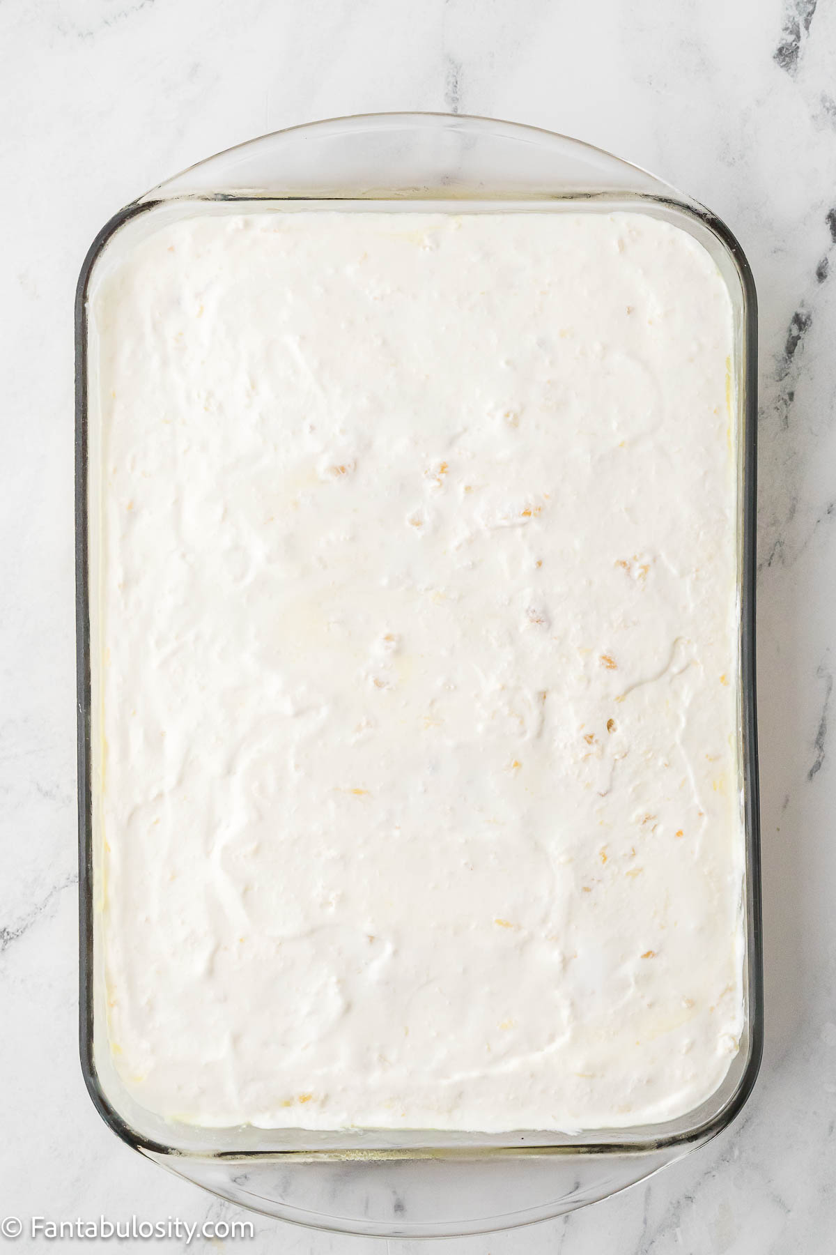 Cool Whip and pineapple on top of baked cake.