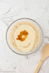 Mashed bananas, with vanilla, and sweetened condensed milk in mixing bowl.