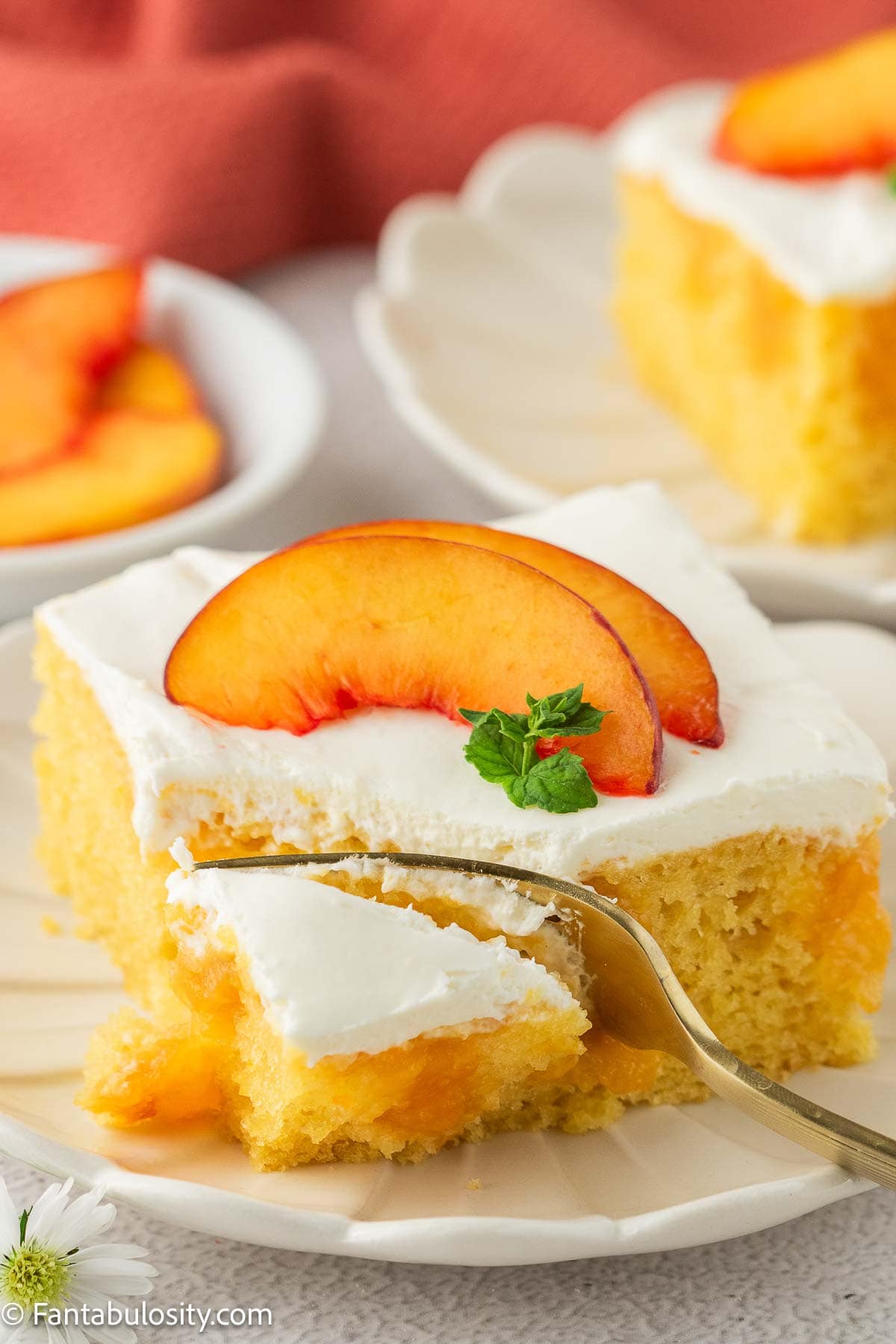 Slice of peaches and cream cake on plate.