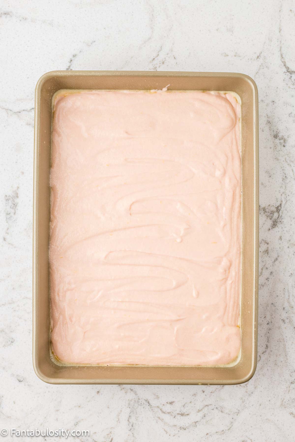 Pink lemonade cake batter in cake pan before baking.