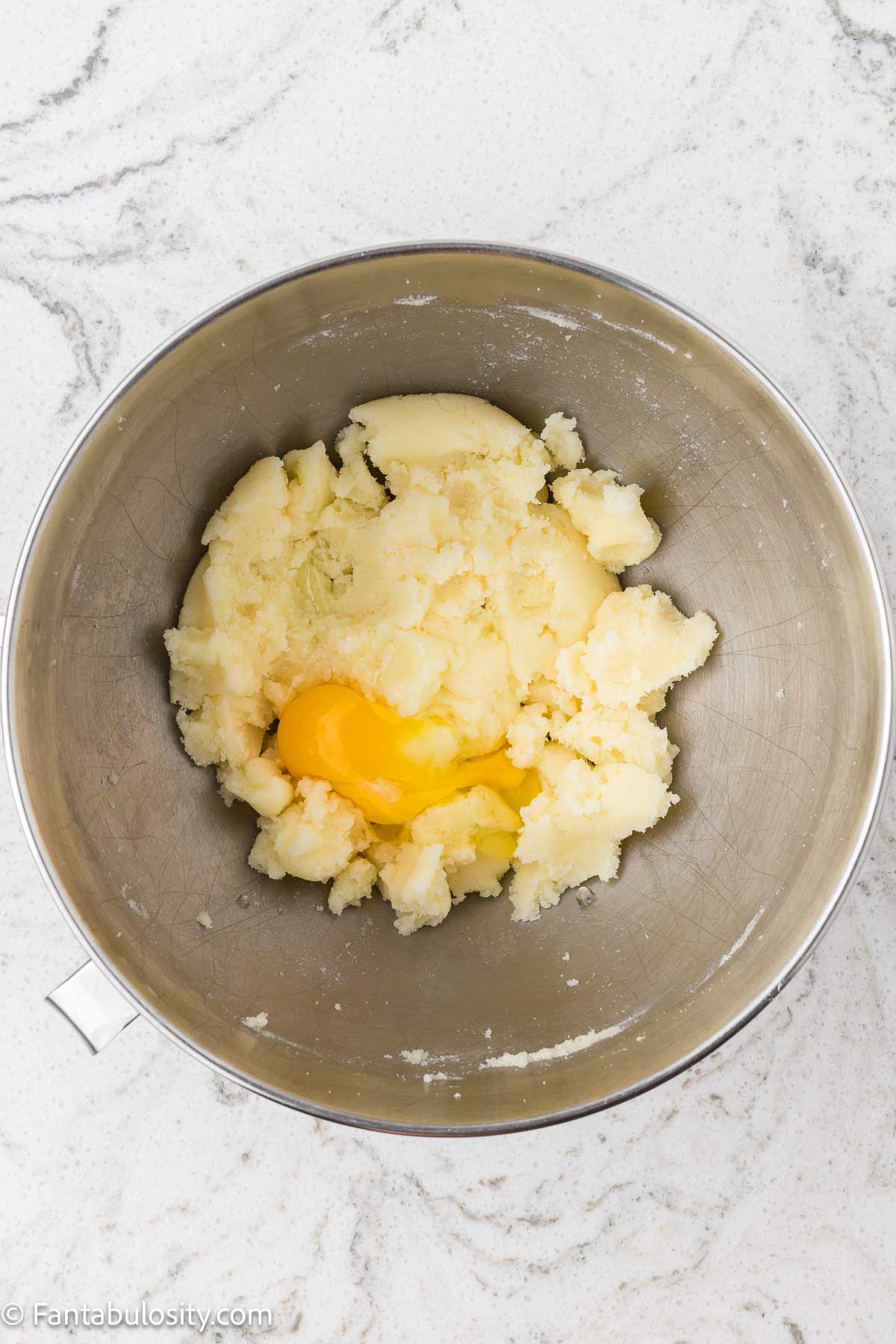 Butter and sugar in mixing bowl, with eggs.