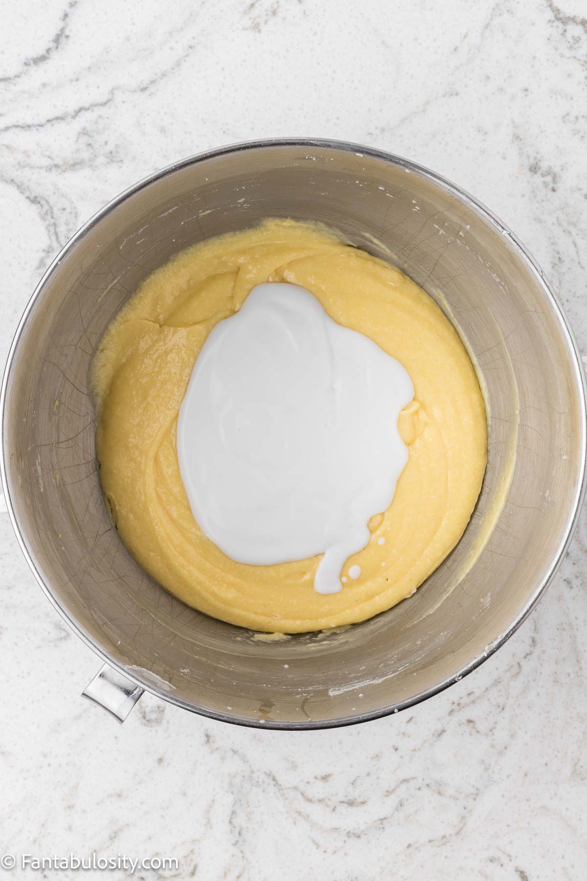Coconut milk and dry ingredients being added in to the mixing bowl.
