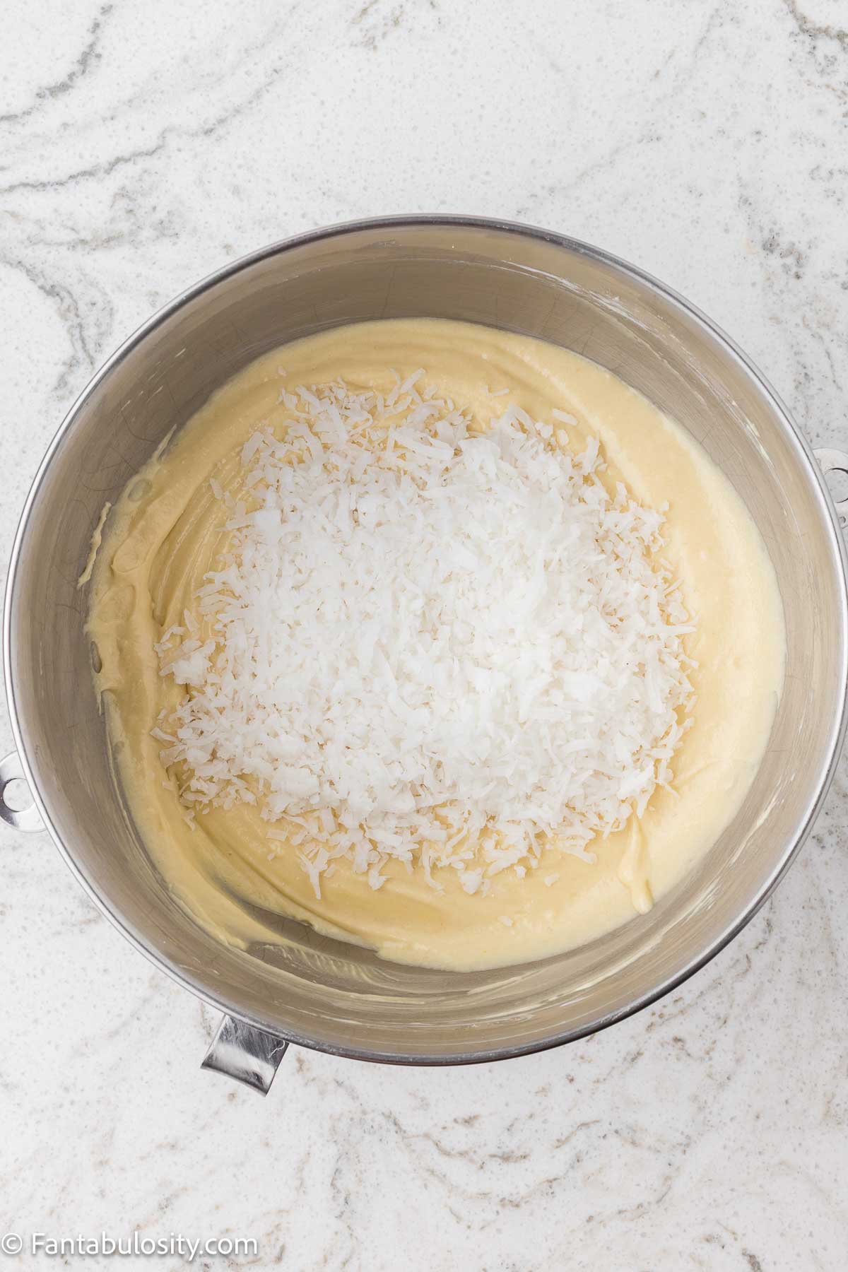 Shredded coconut added to mixing bowl.
