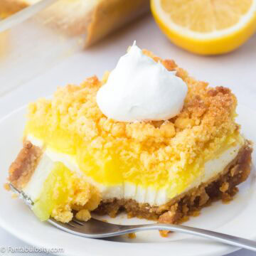 Slice of lemon dump cake on round plate, next to fork.