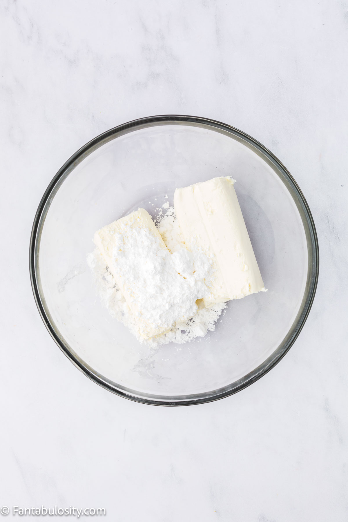 Cream cheese and powdered sugar in mixing bowl.