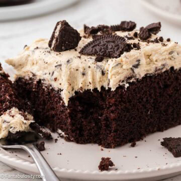 One slice of chocolate cake with Oreo cookie dough frosting on top.