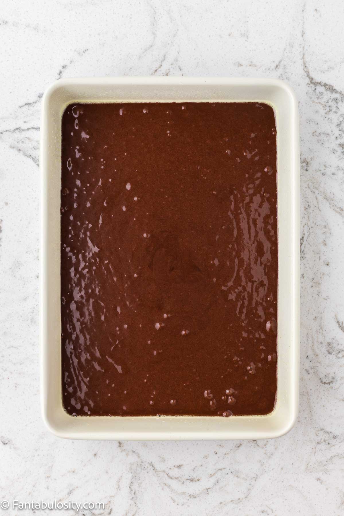 Chocolate cake batter in 9x13 baking dish.