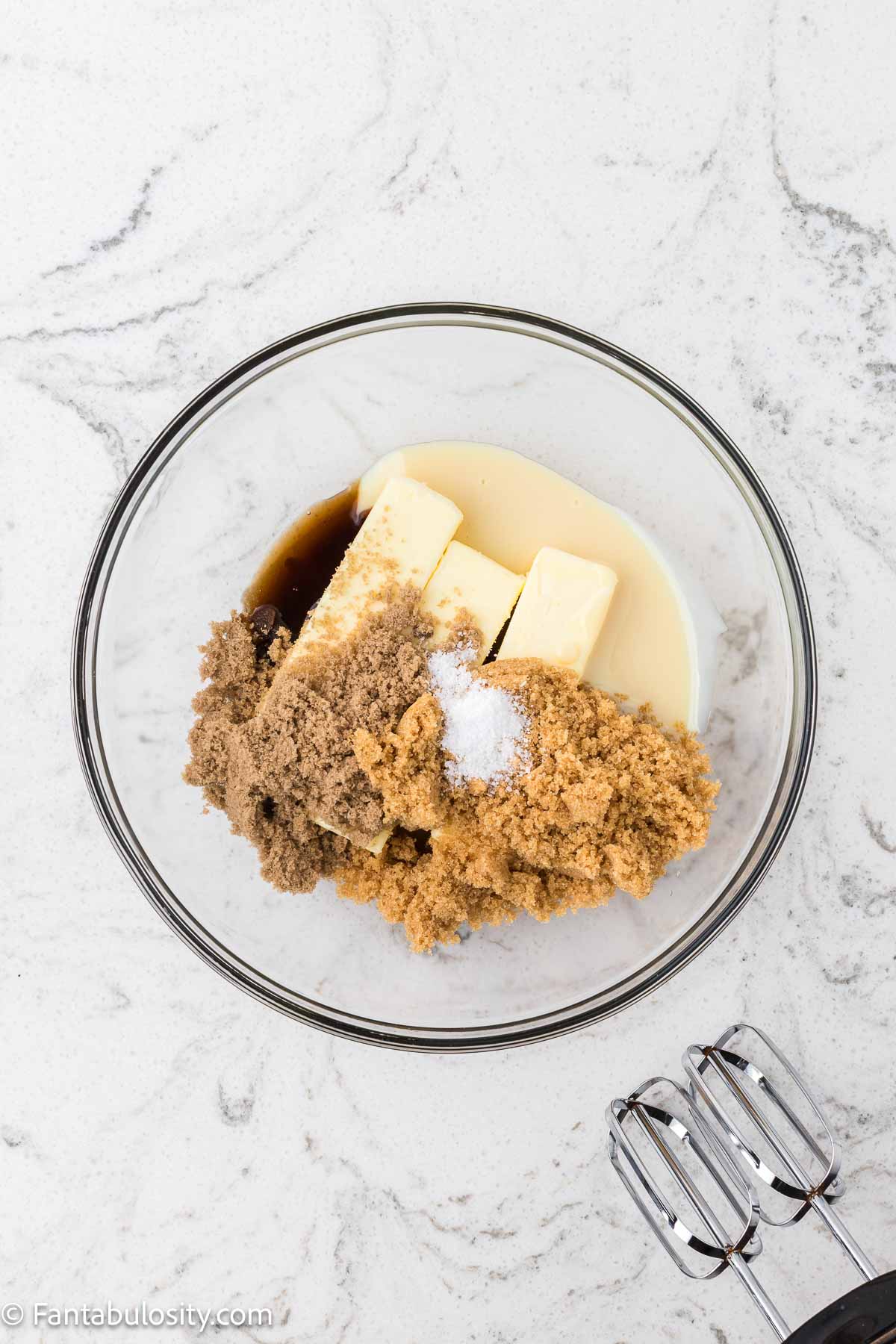 Butter, brown sugars, milk, and vanilla in a mixing bowl to make cookie dough frosting.