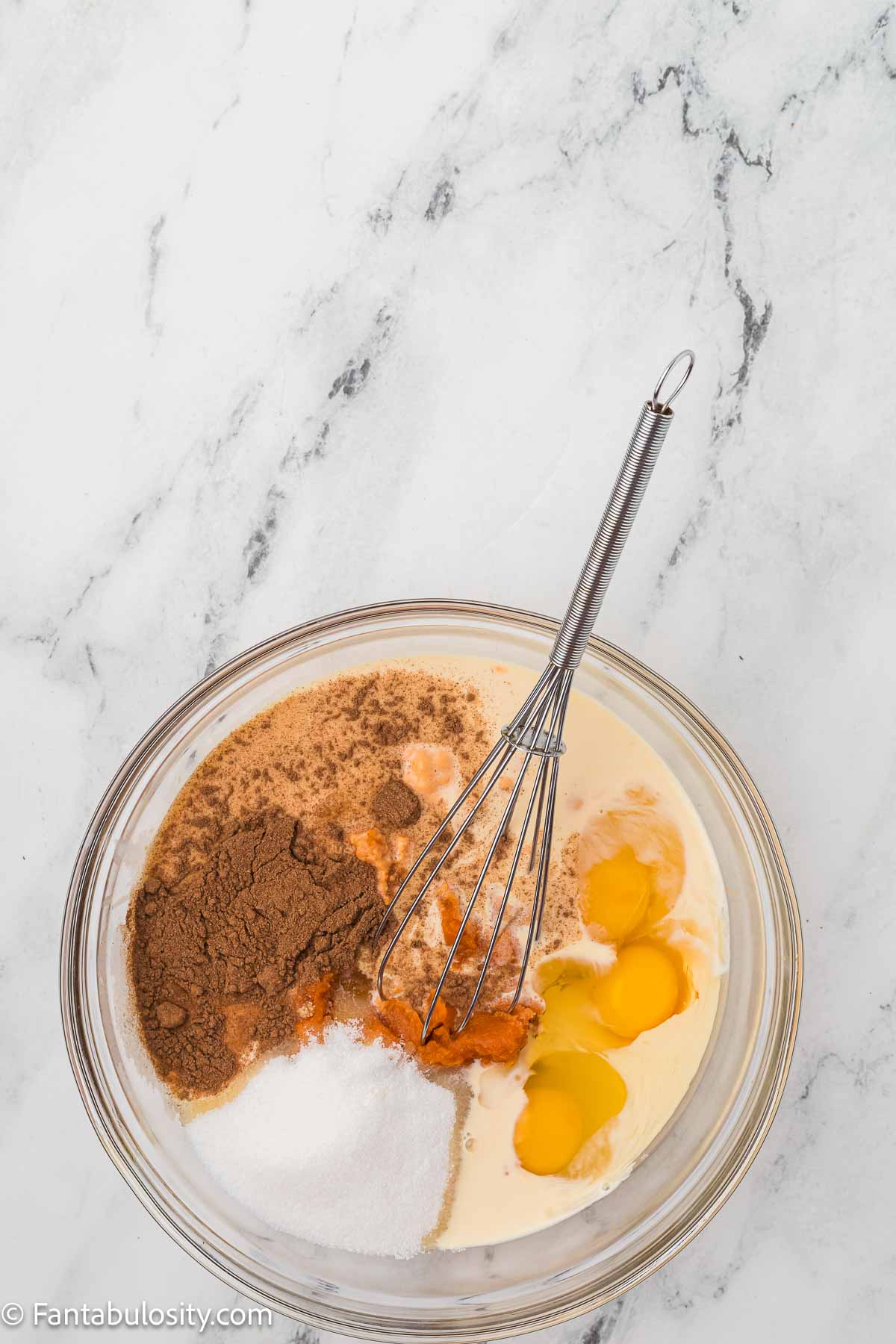 Pumpkin, milk, egg, sugar, pumpkin spice and salt in mixing bowl with whisk.