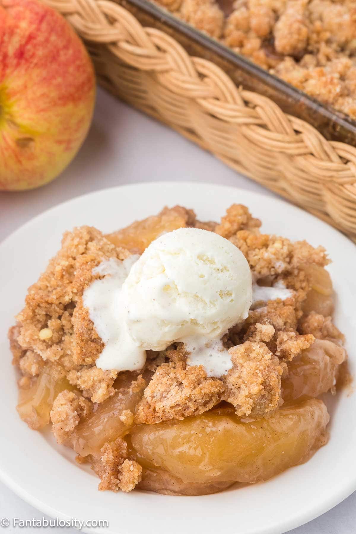 Serving of snickerdoodle apple dump cake on a round plate.