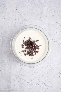 Heavy cream and chocolate chips in mixing bowl to make ganache.