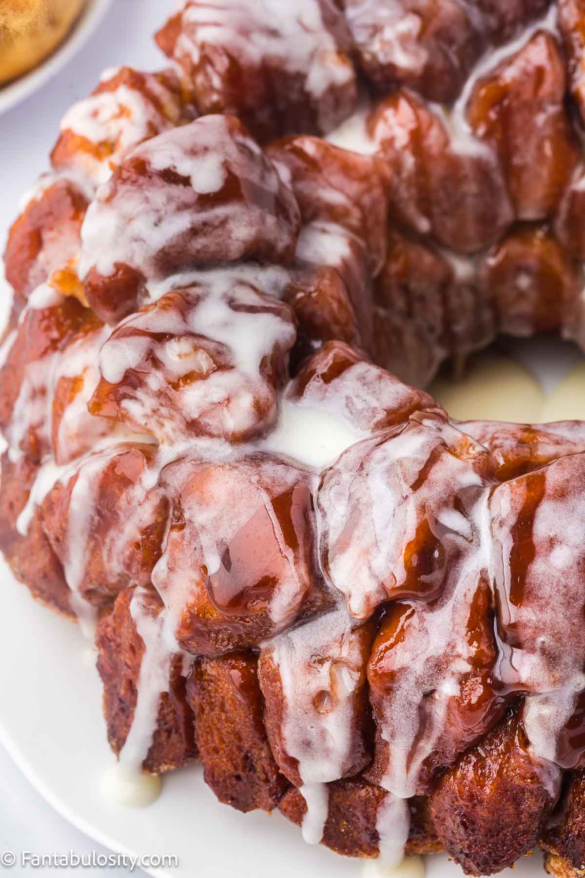 Monkey bread made with cinnamon rolls and a glaze, sitting on platter.